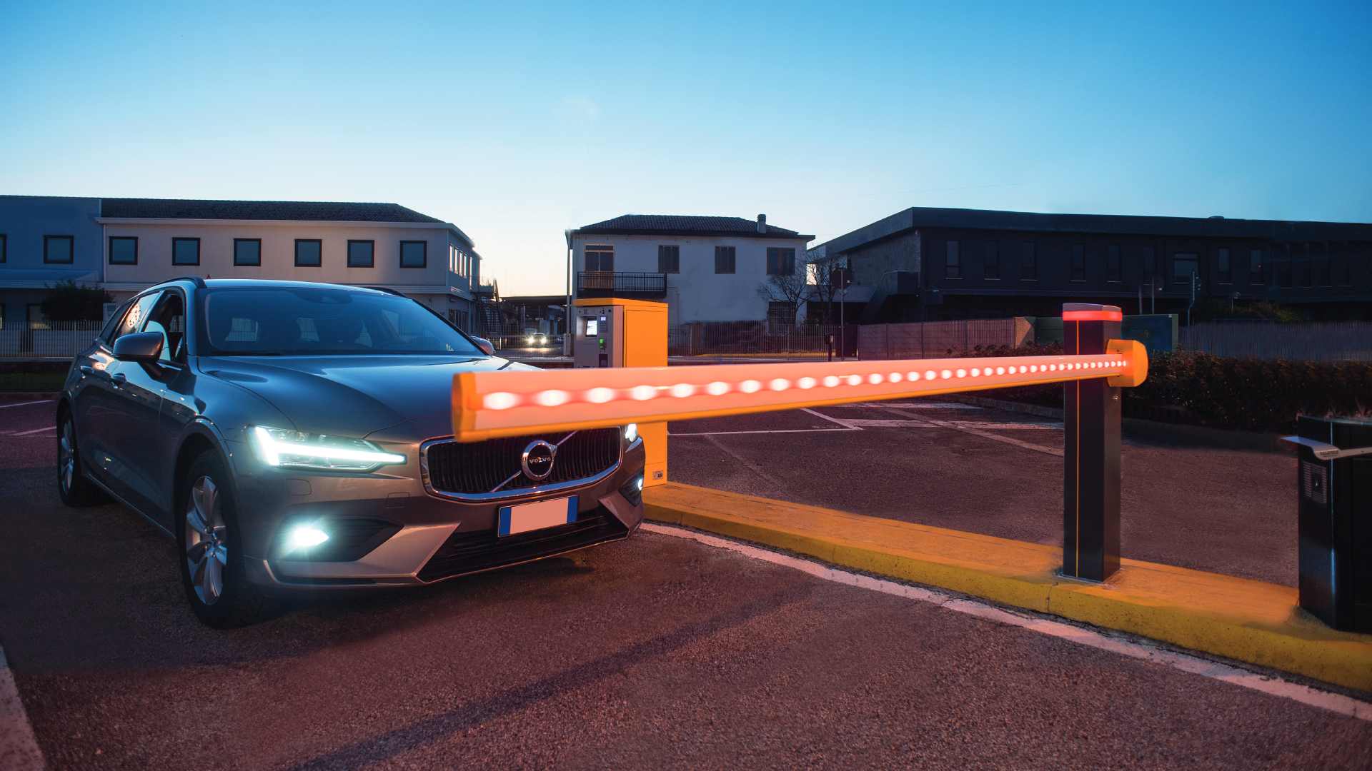 Schrankenanlage Monnes und ein Auto bei Abenddämmerung