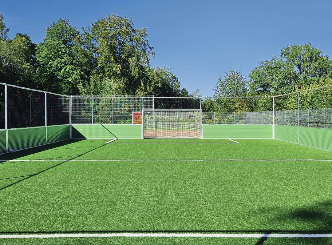 Sportplatz mit Umrandung vor einem Wald