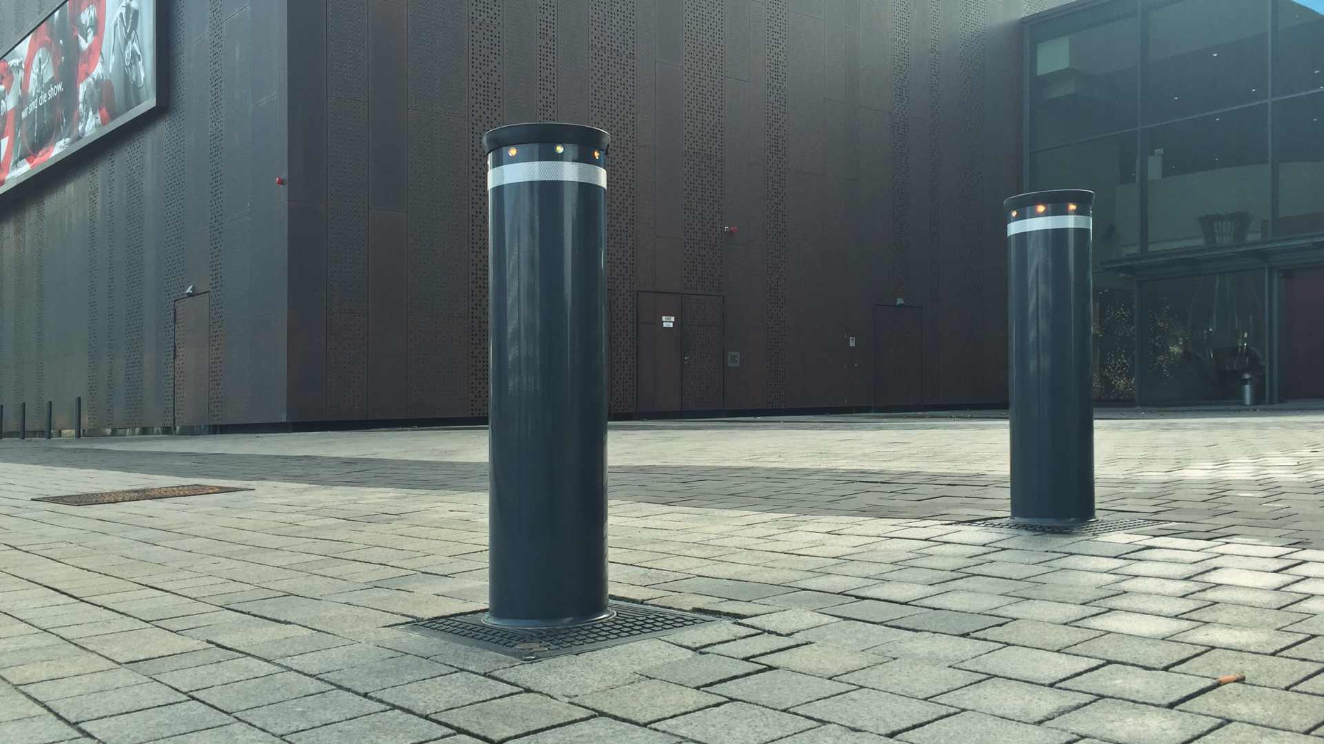 Zwei versenkbare Poller auf einem gepflasterten Weg