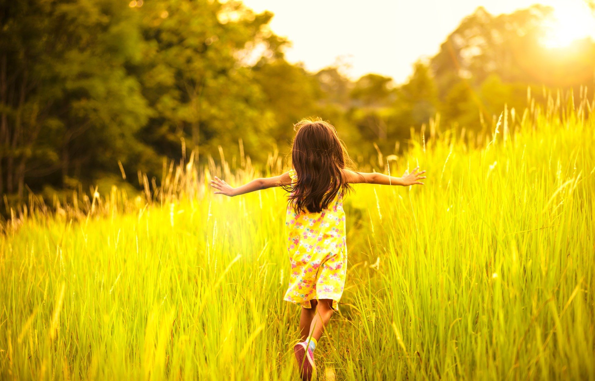 Kind läuft über eine Wiese