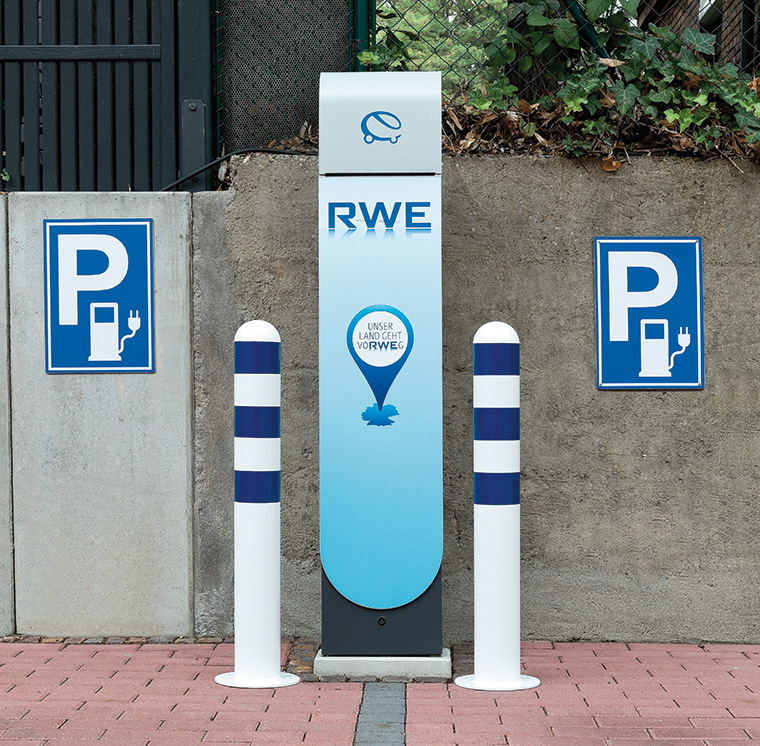 E-Parkplatz mit Ladesäule, Parkschildern und Schutzpollern in blau/weiß