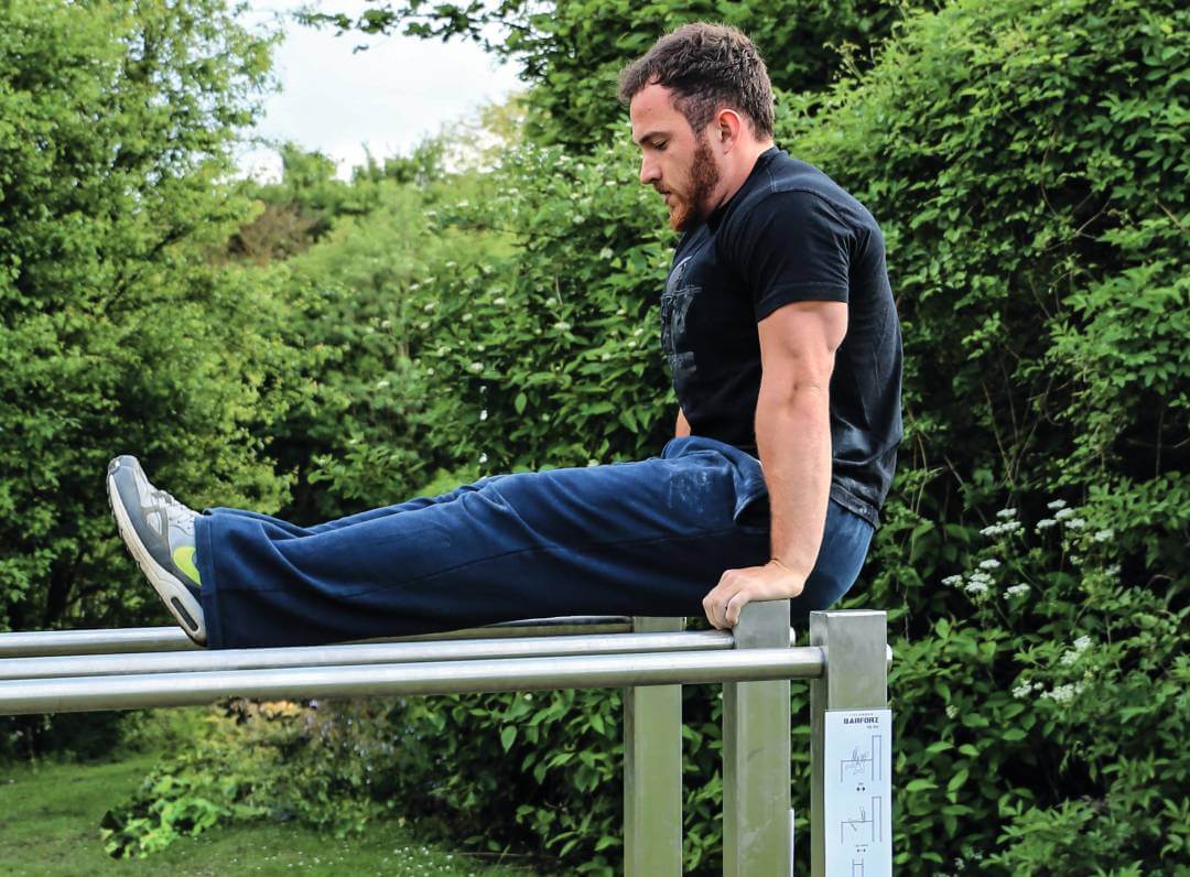 Mann macht Sport auf einem Outdoor Fitness Gerät