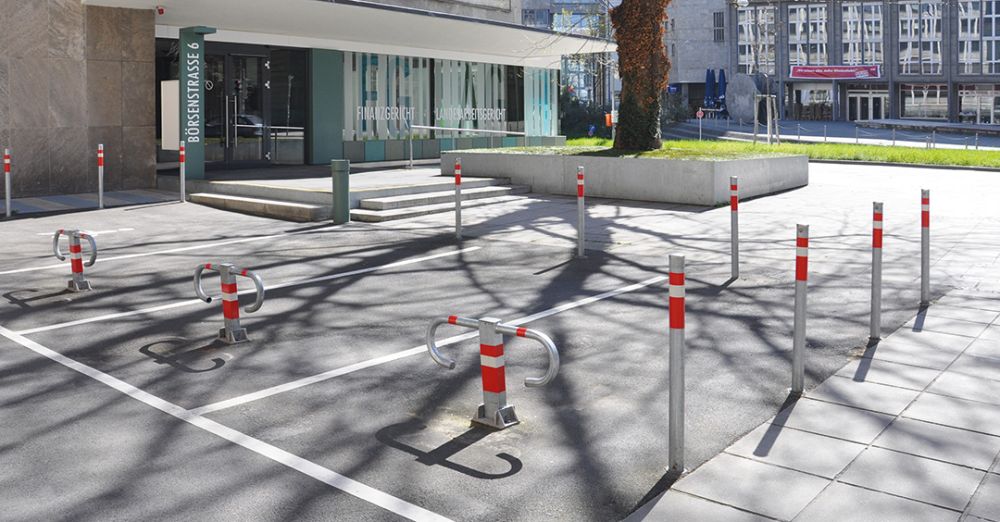 Sperrpfosten RUBI aus Stahl und Parksperre ARONA zur Sicherung eines Parkplatzes