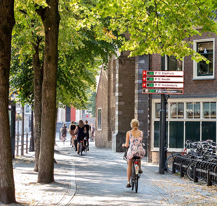 Frau fährt mit dem Fahrrad auf einem Radweg entlang
