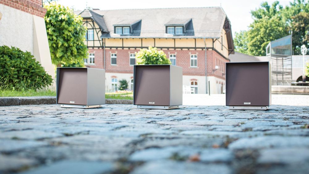 Drei Sitzpoller auf einem gepflasterten Weg