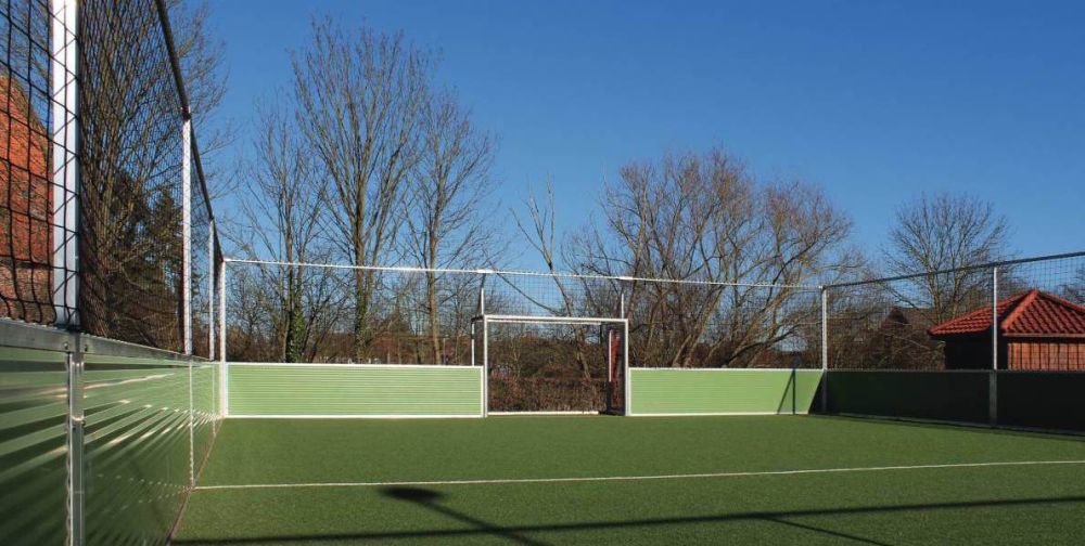 Ein geschlossener Sportplatz vor Bäumen und blauen Himmel