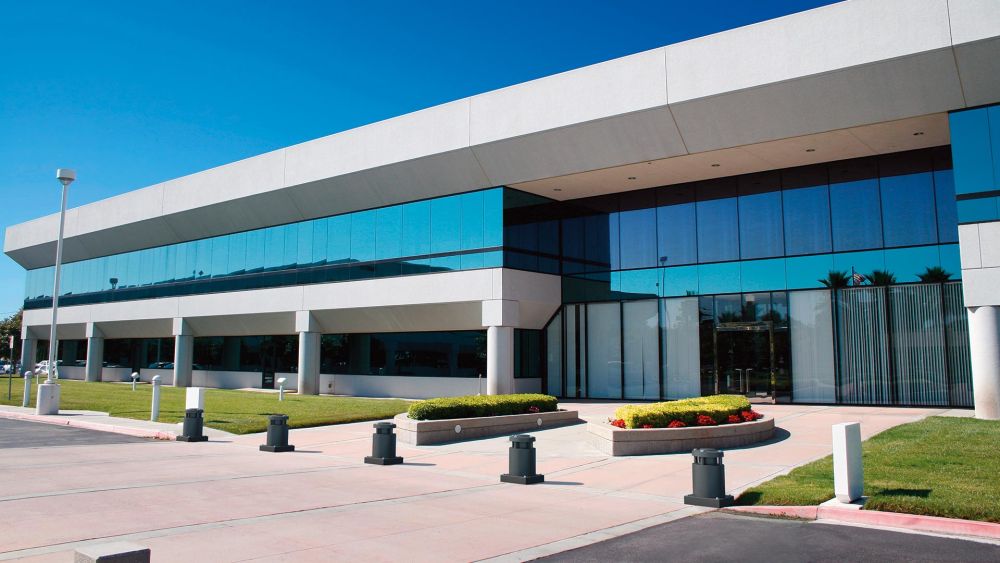 Abwehrpoller mit einem modernen Bürogebäude im Hintergrund