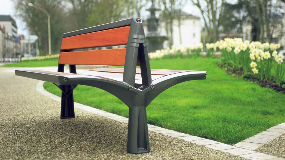 Parkbank aus Holz doppelseitig aus mit Metallgestell auf einem Weg in einem Park