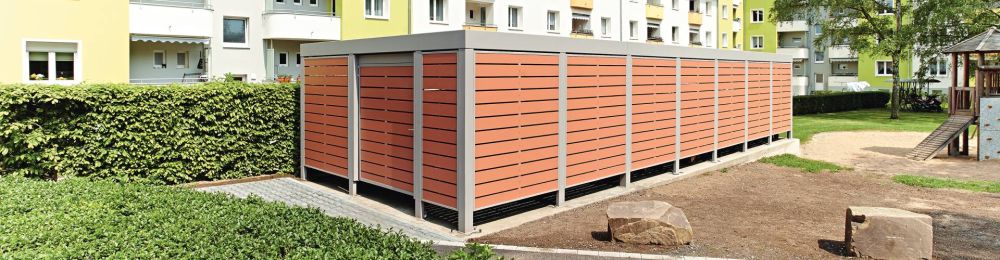 Mülltonnenbox Multiport mit Holzoptik in einer Wohnsiedlung